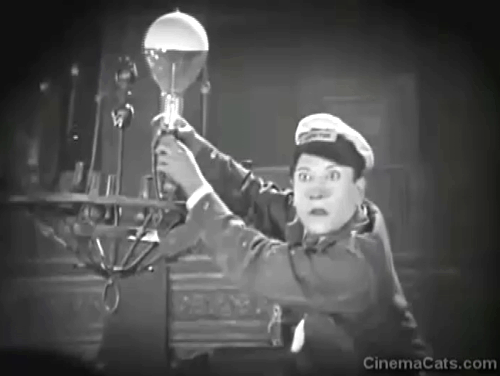 45 Minutes from Hollywood - tuxedo cat startled by falling bulb dropped by Jerry Landy then cartoon black cat walking under towel around Oliver Hardy's legs animated gif