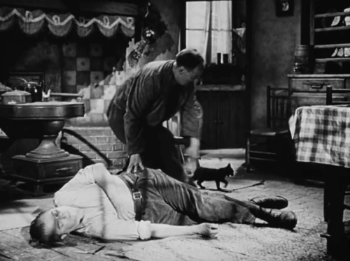 Against the Wind - Max Jack Warner dead on floor with Belgian helper stealing boots and black cat nearby animated gif