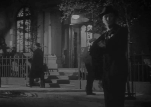 The Agitator - Pettinger outside building with tuxedo cat on steps behind walking down street animated gif