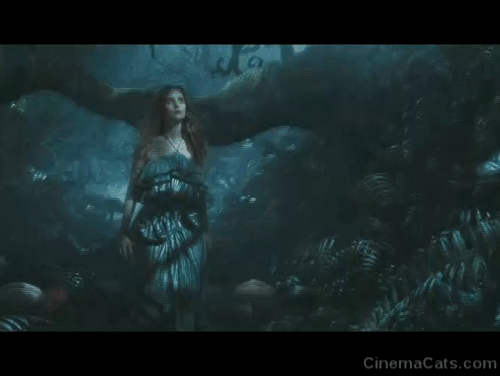 Alice in Wonderland - Cheshire Cat appearing on branch of tree in dark forest behind Alice Mia Wasikowska animated gif