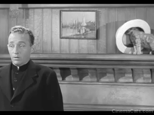 The Bells of St. Mary's - Father O'Malley Bing Crosby talking to nuns with tabby kitten Rosie on mantel looking into his straw hat animated gif