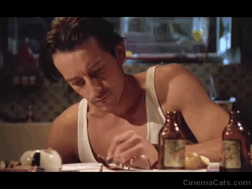 Betty Blue - Zorg Jean-Hugues Anglade looking at white cat on table while writing animated gif