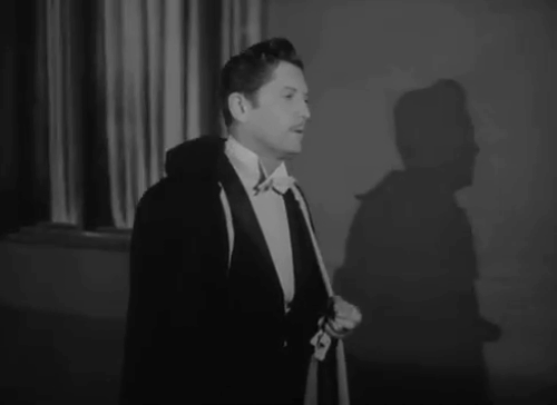 The Catman of Paris - Charles Carl Edmond leaning against wall where black cat scurries away animated gif