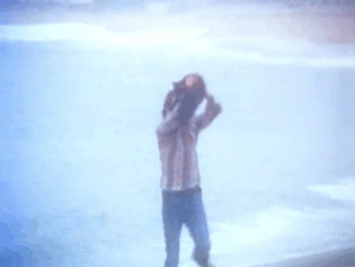 The Cremators - hippie Mason Caulfield running on beach with black cat animated gif