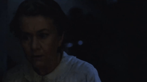 The Dressmaker - black cat slinking away from table in dark room as Nellie Joan Plowright shouts animated gif