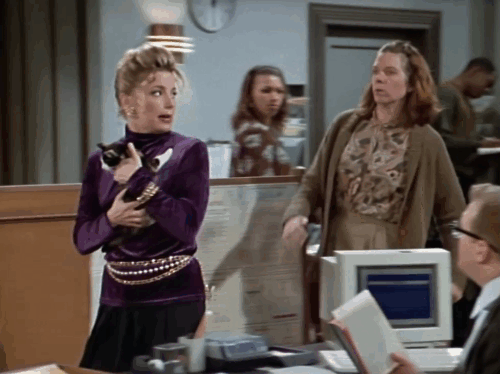 The Drew Carey Show - There Is No Scientific Name for a Show About God - Suzie Angela Dohrmann holding calico kitten with Nora Jane Morris arguing in front of Drew's desk animated gif