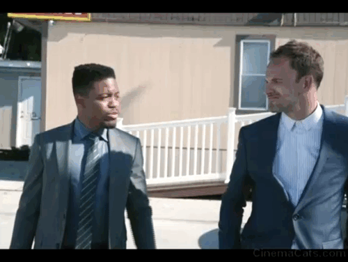 Elementary - Give Me the Finger - black cat walking behind Holmes Jonny Lee Miller and Bell Jon Michael Hill animated gif