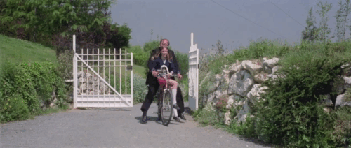 Knife of Ice - Il coltello di ghiaccio - Christina Rosa M. Rodriguez arriving on bike with black and white kitten she shows to Martha Carroll Baker animated gif