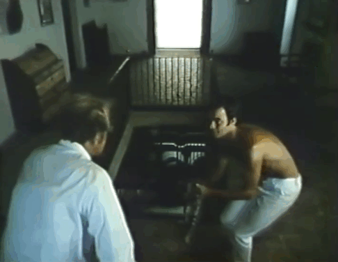 Laughter in the Dark - tabby cat being used at top of stairs by Herve Jean-Claude Drouot to lure More Nicol Williamson closer then tossed into chest to make More fall down stairs animated gif