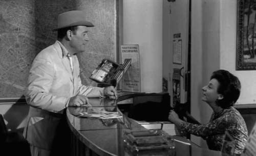 Lucky Jo - Eddie Constantine standing at front desk with Marcelle Ranson-Hervé holding onto fidgety black cat Napoleon animated gif