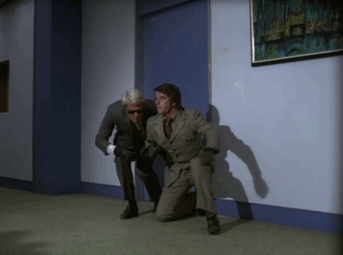 Mission: Impossible - Blind - Phelps Peter Graves and Johnny Peter Brown trying to sneak by security guard feeding ginger and white cat animated gif