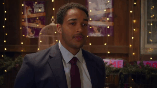 Puppy Love for Christmas - Dylan Ezekiel Simat with white cat Snowball looking sideways in cage as Annie Georgia Flood in red dress approaches animated gif