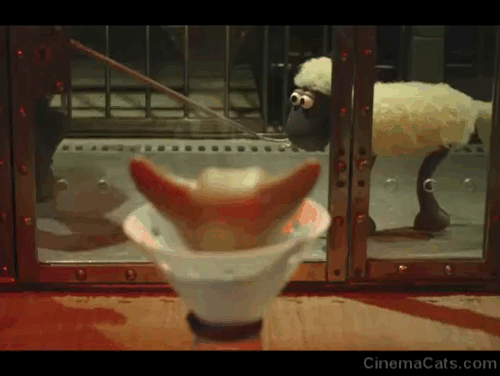 Shaun the Sheep Movie - Shaun the Sheep startled by Hannibal Lecter cat inside glass cell wearing cone animated gif