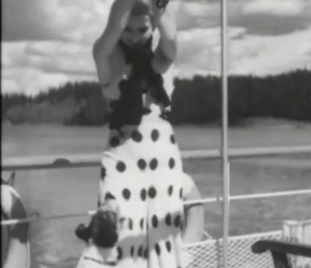 En stilla flirt - Diddi Tutta Rolf teasing terrier Chamo by holding up white cat Murre until dog falls off boat animated gif