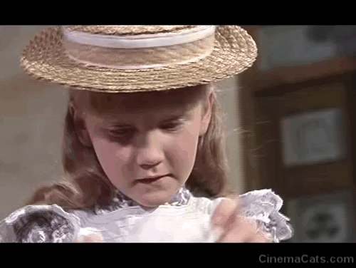 The Three Lives of Thomasina - marmalade tabby cat being dressed in bonnet by Mary Karen Dotrice animated gif