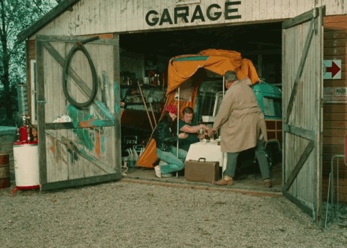 Trafic - tuxedo cat running and jumping onto table in front of Marcel Fraval animated gif