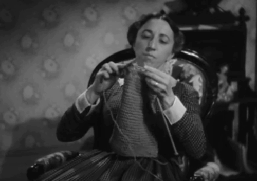 The Villain Still Pursued Her - tabby cat swishing tail out of way of rocking chair as Mrs. Wilson Margaret Hamilton knits and rocks animated gif