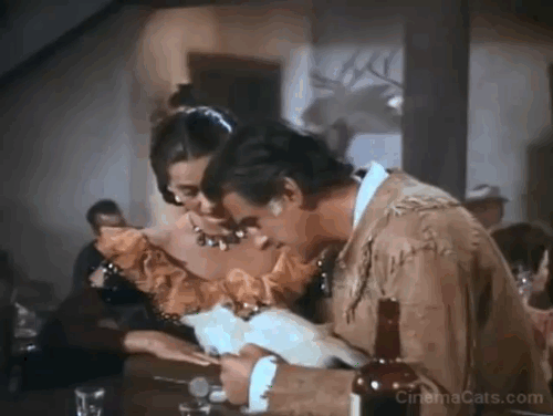 The Wild North - Jules Vincent Stewart Granger and Indian girl Cyd Charisse spin coin for yellow tabby kitten animated gif