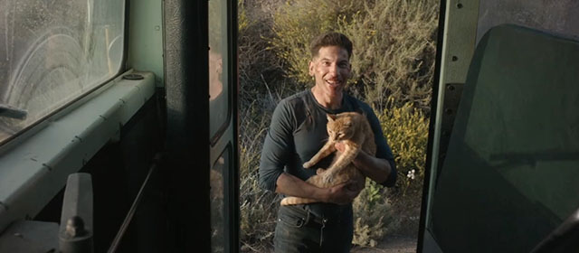 The Accountant 2 - Braxton Jon Bernthal holding ginger tabby cat outside door of bus