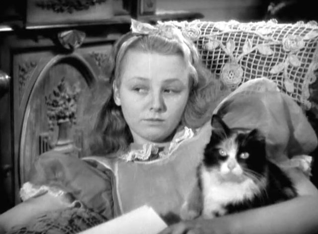 Alice in Wonderland - Alice Charlotte Henry sitting in chair with longhair calico cat Dinah