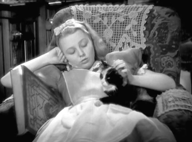 Alice in Wonderland - sleepy Alice Charlotte Henry sitting in chair with longhair calico cat Dinah