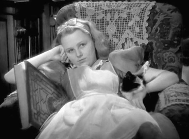 Alice in Wonderland - Alice Charlotte Henry sitting in chair with longhair calico cat Dinah