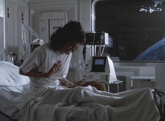 Aliens - Ripley Sigourney Weaver wakes up with orange tabby cat Jones at her side
