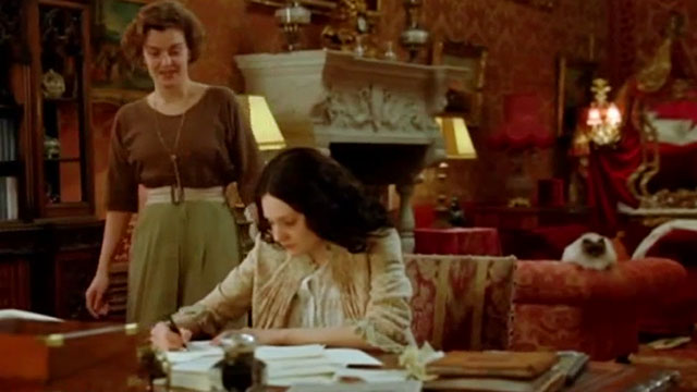 Angel - Romola Garai writing with Nora Lucy Russell and longhair seal point cat behind