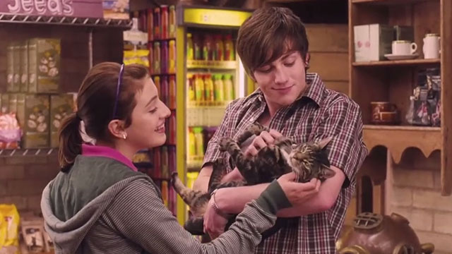 Angus, Thongs and Perfect Snogging - brown tabby cat Jubbly being held by Robbie Aaron Taylor-Young with Georgia Groome