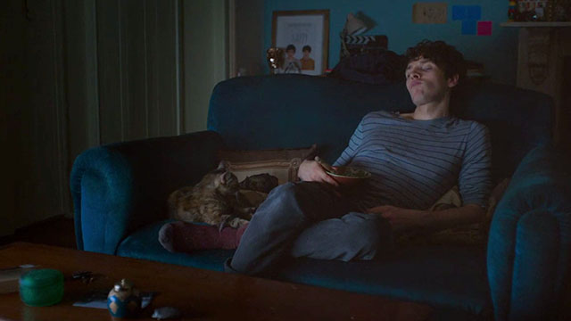 Benjamin - Colin Morgan sitting on couch with torbie cat
