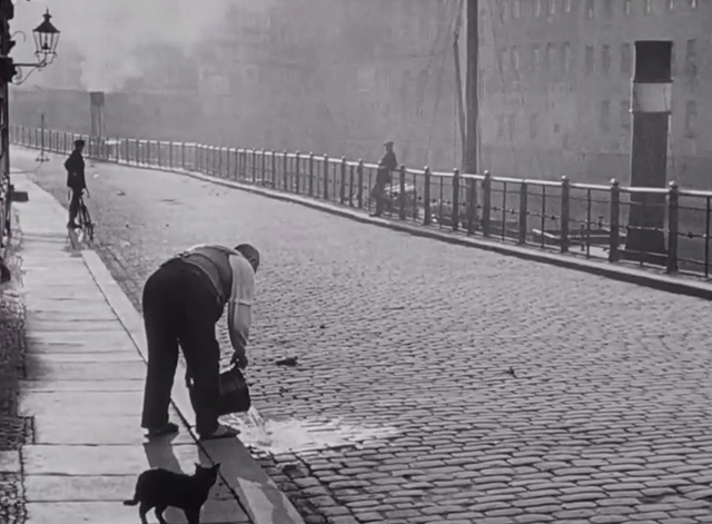 Berlin: Symphony of a Great City - black cat on sidewalk as man pours bucket of water into street