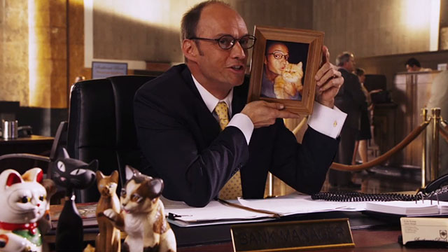 Beverly Hills Chihuahua 2 - Mr. Kroop Brian Stepanak holding framed photo of himself and orange and white exotic shorthair cat Little Prince Albert