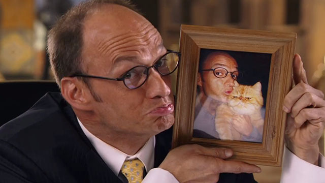 Beverly Hills Chihuahua 2 - Mr. Kroop Brian Stepanak holding framed photo of himself and orange and white exotic shorthair cat Little Prince Albert