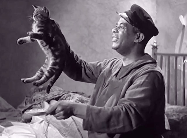 Big Fella - Corny Lawrence Brown holding up tabby kitten by scruff