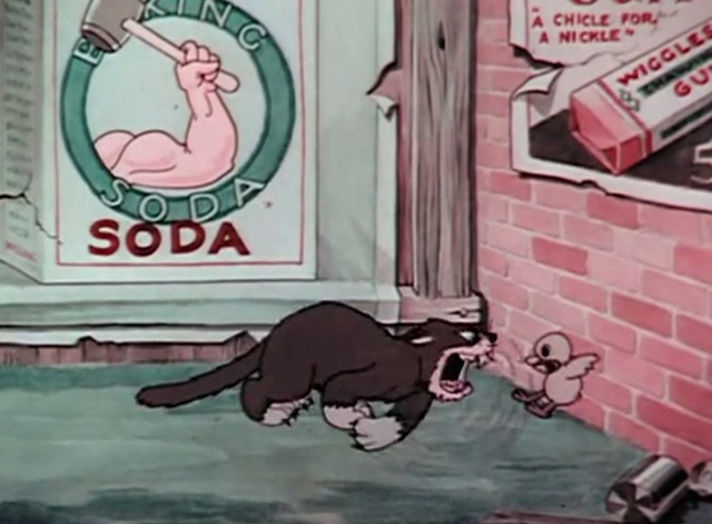 Billboard Frolics - hungry gray cat taking swipe at baby chick