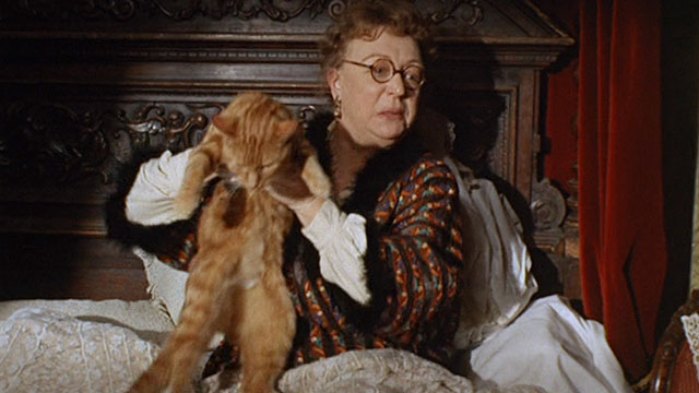 Bitter Harvest - Mrs. Jessop Thor Hird picking up ginger tabby cat in bed