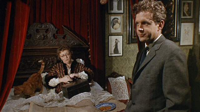 Bitter Harvest - Mrs. Jessop Thor Hird picking up ginger tabby cat in bed with Bob John Stride