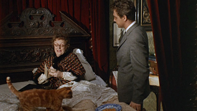 Bitter Harvest - Mrs. Jessop Thor Hird picking up ginger tabby cat in bed with Bob John Stride