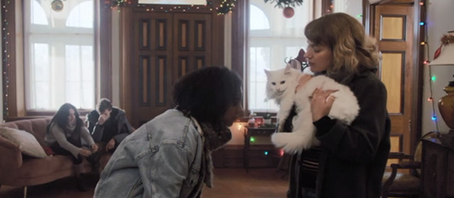 Black Christmas 2019 - Riley Imogene Poots showing black paw on long haired white cat Claudette Rana