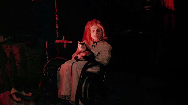 Black Sabbath - I I tre volti della paura - body of medium holding tuxedo cat in rocking chair