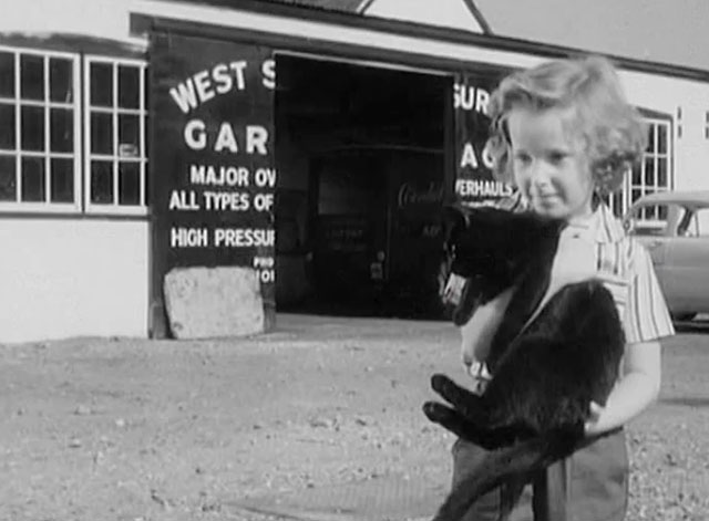 Bond of Fear - Ann Marilyn Baker holding black cat at gas station