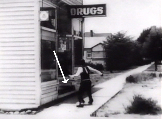 The Cameraman - black cat on drugstore step as Buster Keaton approaches