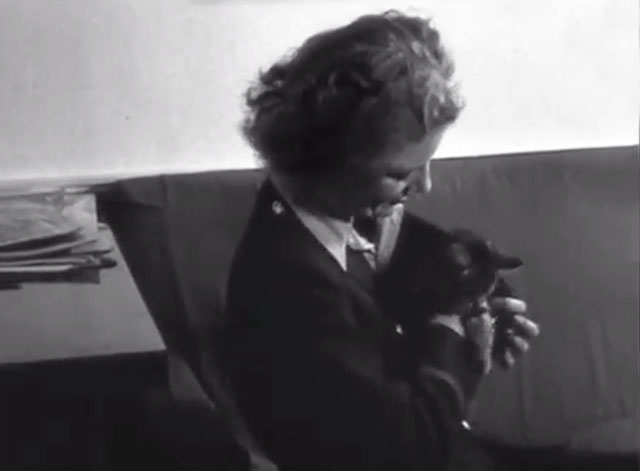 Candid Camera with Lee Miller - sitting on couch tucking tabby kitten inside jacket