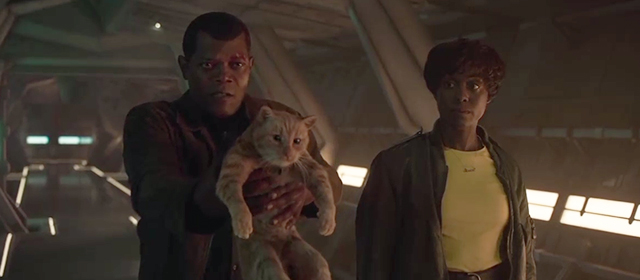 Captain Marvel - Nick Fury Samuel L. Jackson holding ginger tabby cat Flerken Goose up like weapon with Maria Lashana Lynch