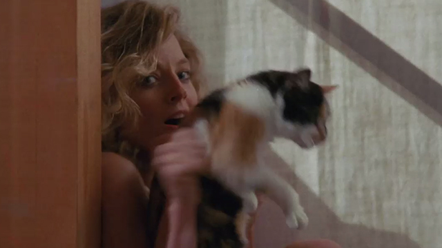 Catchfire - Anne Jodie Foster cowering in corner as tortoiseshell cat Frida jumps from her arms