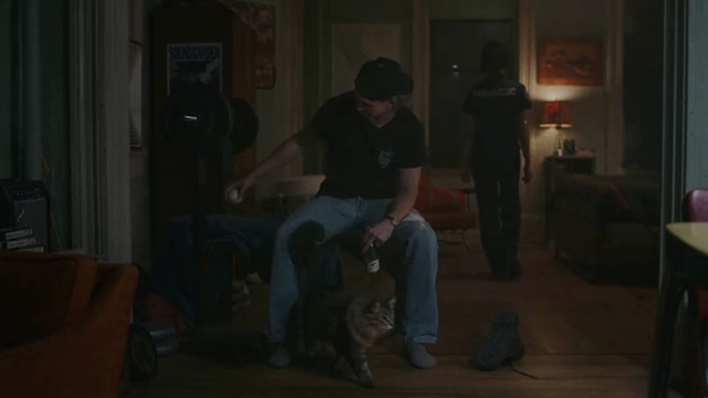 Caught Stealing - Hank Austin Butler sitting in apartment with longhair brown tabby cat Bud Tonic