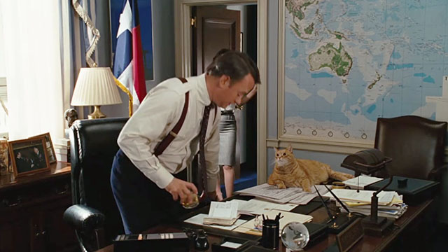 Charlie Wilson's War - ginger tabby cat lying on desk with Tom Hanks