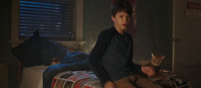 Child's Play - Andy Gabriel Bateman sitting on bed with ginger tabby cat Mickey Rooney