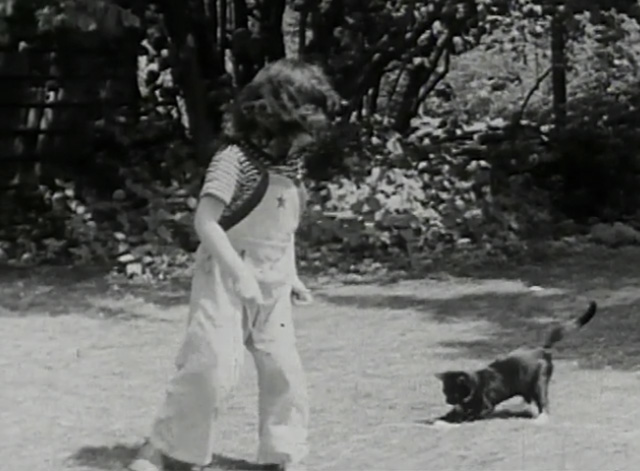 A Child Went Forth - tuxedo kitten chasing string pulled by little girl