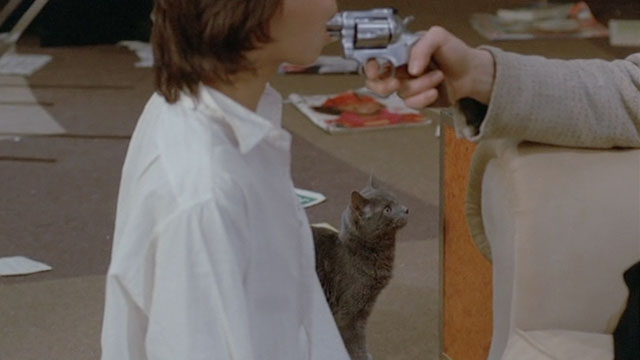 Le Choc - The Shock - gray cat Soudan looking at couch and man with gun in Mathilde's mouth